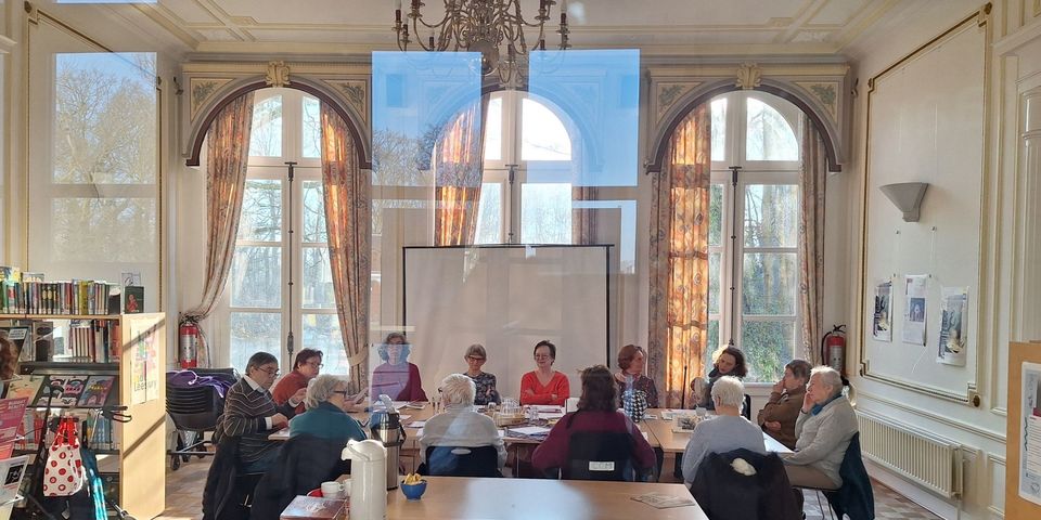 Een groep van SamenLezen samen aan tafel in een zaal in kasteel Bouckenborgh